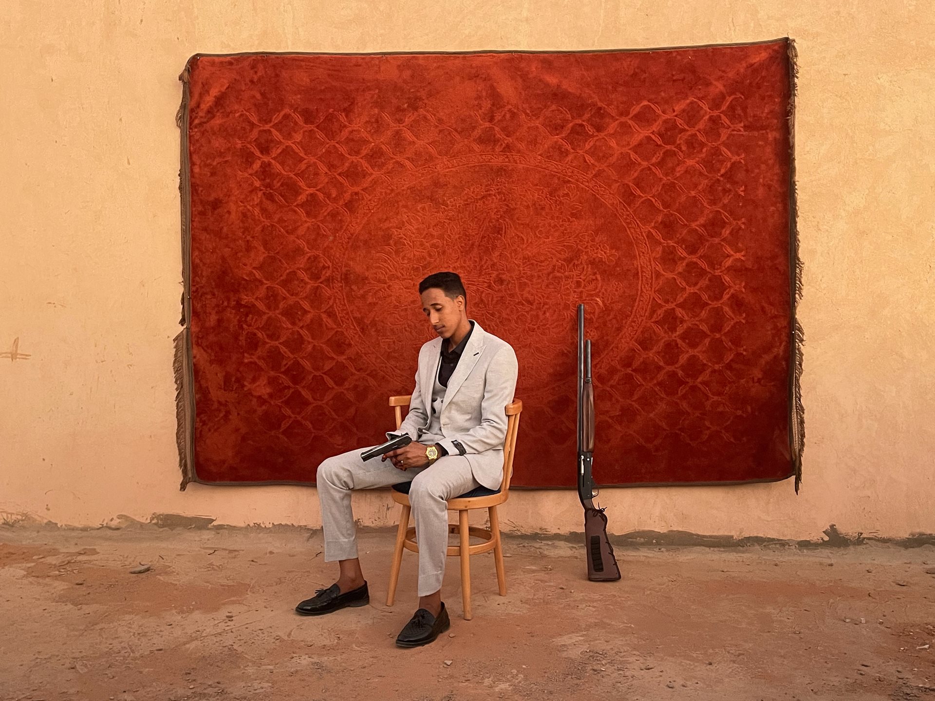 The groom poses for a portrait at his wedding in Omdurman, Sudan. In Sudan, announcing a wedding with celebratory gunfire is a tradition. The weapon symbolizes both the joy of marriage and the reality of war.